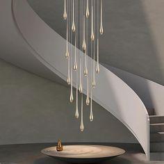 a chandelier hanging from the ceiling in a room with spiral staircase and circular table