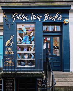 a store front with blue painted walls and black wrought iron railings on the outside