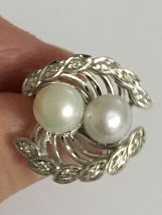 Details: A Unique and one of a kind Ring Handmade Vintage Ring Custom Made Ring (Estimated Late 1960's Early 1970's) 14Karat White Gold Ring Shank is nice and wide 2 Cultured Pearls in the Center One Pearl color is White the other has a silver tone color There are 12 diamond Stones around the Crown Estimate Total Weight .25ct Ring weight : 7.3 Grams Ring is appraised for the value of $2750 Since the following ring is Vintage no changes will be made to the ring Ring will be shipped via FEDEX seco Classic White Multi-stone Cluster Ring, Heirloom Pearl Open Ring For Formal Occasions, Heirloom Style Pearl Open Ring For Formal Occasions, Elegant White Multi-stone Diamond Ring, Formal Heirloom Pearl Open Ring, Heirloom Style Formal Pearl Open Ring, Vintage White Gold Multi-stone Ring, White Gold Multi-stone Diamond Ring For Anniversary, Multi-stone White Gold Diamond Ring For Anniversary