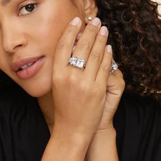 a close up of a person with a ring on their finger and her hand near her face