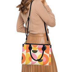 • Elevate your style with our retro style 60s Space Age Opt Art Handbag, a chic fusion of mod and vintage aesthetics inspired by the iconic designs of the 60s.• This Mod 60s Handbag features a mesmerizing geometric opt art pattern print in vibrant shades of orange, pink, yellow, and black, adding a bold and artistic touch to any outfit.• Crafted from premium PU leather, this Retro Handbag Women boasts an exquisite zipper closure and comes with a removable strap for added versatility.• Available in three sizes - small, medium, and large - and with two handle options in black and white, this 60s Style Handbag offers both style and practicality for every occasion.**Designed in California by Trendy Hip Buys. Made to order from overseas. 60s Space Age, Opt Art, 1940s Fashion Dresses, Vintage Inspired Shoes, Orange Handbag, 1950s Fashion Dresses, Vintage Style Hat, Mod 60s, Men's Vintage Style