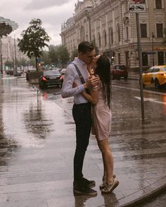 a man and woman kissing in the rain