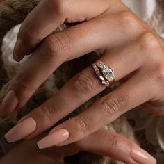 a woman's hand with two rings on her fingers and one ring in the middle