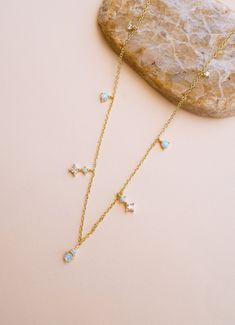 The Mystic Sky Opal Necklace is simply enchanting! This dainty necklace features delicate opal and cubic zirconia dangles set in a 14k gold-plated design. Each opal glimmers with a mystical glow, making this necklace a stunning addition to your necklace stack. Endless compliments guaranteed! NECKLACE FEATURES Material: Brass, Lab Opal Stone, White Cubic Zirconia Dimensions/Size: 15.75" length + 2.25" extender (can be worn up to 18") Finish: 14k Gold Plating Opal Choker Necklace, Gold Opal Necklace, Opal Choker, Stolen Image, Galaxy Jewelry, Necklace Stack, Dangle Necklace, Choker Gold, The Mystic