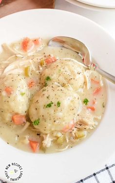 two dumplings covered in gravy sit on a white plate with a spoon