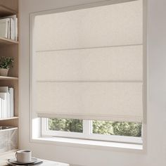 a room with a window covered in blinds and a cup on the table next to it