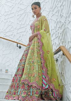 Step into the spotlight with this exquisite Multi Colour Embroidered Bridal Lehenga Set. Perfect for summer weddings or Mehendi ceremonies, this set boasts a captivating multi-coloured organza blouse embellished with intricate resham and patra work. The ensemble is completed with a dazzling multi-coloured organza lehenga and a matching yellow net dupatta. Be the centre of attention and make a statement with this stunning bridal outfit. Composition : Blouse- Organza, Lehenga- Organza and Dupatta- Net Care: Dry Clean Only and Vacuum Storage This product can be customized for sleeves, length of blouse and neckline Delivery : 6-8 weeks as the product is hand crafted. Check Size Guide or choose MySize for free customisation (All Sizes above XL can be made at 15% additional cost) For more inform Green Georgette Lehenga With Cutdana, Green Georgette Lehenga With Cutdana Details, Green Organza Dress With Cutdana, Green Organza Dress With Cutdana Detailing, Semi-stitched Multicolor Lehenga With Sheer Dupatta, Green Georgette Gown With Cutdana, Green Georgette Gown With Cutdana Detail, Green Cutdana Georgette Gown, Floor-length Sharara With Dupatta For Navratri