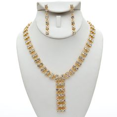 This jewelry set is stunning! It is encrusted with clear, sparkling rhinestones and cream pearls along a gold plate. It is perfect for weddings, proms, formals, parties, pageants, and more. It coordinates with any color or style wedding dress or formal ensemble. Glamorous Gold Jewelry Sets For Party, Gold Dangle Bridal Necklace For Party, Formal Metal Jewelry Sets With Rhinestones, Dazzling Gold Jewelry Sets For Party, Elegant Gold Crystal Rhinestone Necklace, Elegant Gold Rhinestone Necklace For Formal Occasions, Glamorous Gold Cubic Zirconia Bridal Necklace, White Gold Plated Jewelry Sets For Party, Gold Cubic Zirconia Bridal Necklace For Party