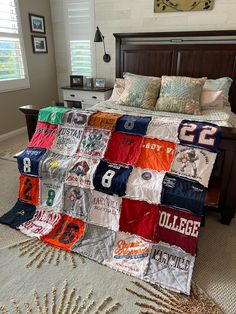 a bed with a quilt made to look like a college football team jersey on it