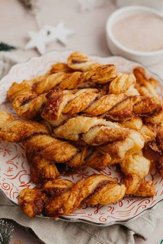 some fried food on a plate next to a cup