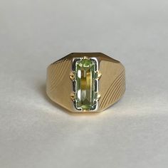 Mid Century Italian 18K Green Spinel Ring, Size 5.5, 3.5grams Size: 5.5 Weight: 3.5 grams Stone: Green Spinel Size Stone: ca. 10mm x 4mm   Number of Gemstones: 1 Cut: Emerald Bandwidth: ca 3.2mm at smallest point Markings:  Condition: Good preowned,  usage throughout -refer to pictures for condition.  All jewelry will be professionally cleaned before shipping and come in a beautiful little gift box. Returns accepted but are subjected to a 8% restock fee. Returns are only accepted for national orders. Luxury Yellow Gold Peridot Rings, Elegant Yellow Hallmarked Signet Ring, Formal Rings With Polished Peridot, Green 14k Stamped Signet Ring, Green Signet Ring With Polished Finish For Promise, Classic Green Signet Ring For Anniversary, Green Classic Signet Ring For Anniversary, Formal Green Sapphire Ring With Vvs Clarity, Formal Peridot Rings With Polished Finish