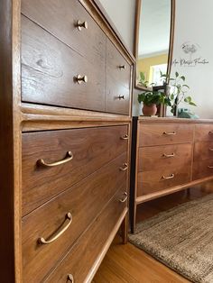 a large wooden dresser sitting on top of a hard wood floor next to a mirror