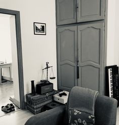 a living room filled with furniture next to a tall wooden door and piano keys on the floor