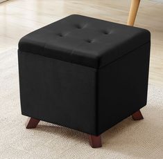 a black ottoman sitting on top of a rug