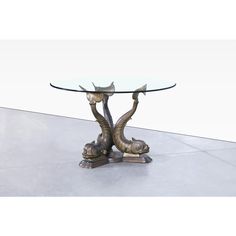 a glass and metal table with an elephant head on it's base is shown