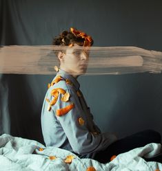 a woman sitting on top of a bed covered in orange peels