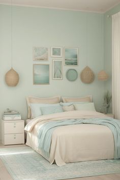 a bedroom with mint green walls and pictures on the wall above the bed, along with an area rug