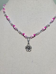 Metal flower charm with pink glass accent beads Pink Flower Charm Necklace With Flower Pendant, Pink Flower Charm Necklace, Pink Adjustable Flower Shaped Necklace, Adjustable Pink Flower-shaped Necklace, Pink Beaded Charm Necklace With Round Beads, Pink Beaded Charm Necklaces With Round Beads, Pink Adjustable Flower Pendant Necklace, Pink Pendant Charm Necklace With Lobster Clasp, Silver Beaded Flower Pendant Necklace