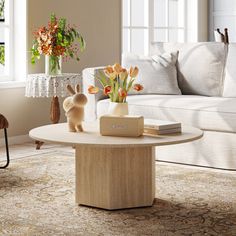 a living room filled with furniture and flowers on top of a table in front of a couch