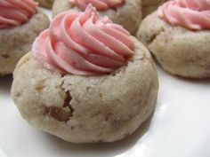 small cookies with pink frosting on a white plate