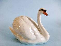 a white swan figurine sitting on top of a blue surface