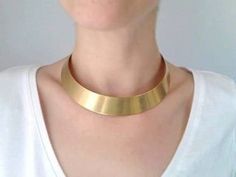 So chic and sleek. Add some oomph to your look with this simple but super elegant choker. The gold tone choker looks great on any complexion and is an eye-catching statement piece that anyone can pull off ! The model has a neck circumference approx 15 inches. The choker has a circumference approx 14 inches. One size, fit most. The choker comes without clasp. Contains no lead or nickel. Do not perfume over it or subject it to any liquid substances. I love the pure metal. But over time, metal will African Choker, Girls Choker, Elegant Choker, Gold Collar Necklace, Bib Collar, Boho Choker, Statement Choker, Neck Choker, Gold Collar