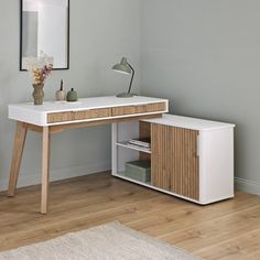 a white desk with drawers and a mirror on the wall above it in a room