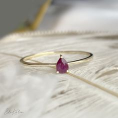 One piece of delicate 14K yellow gold pear shape, solitaire natural ruby stone promise ring  This ring can be perfectly stacked with the below ring from our store: https://etsy.me/3h4pNni * Metal: 14K solid gold * Stone: 4x3mm natural ruby * Band thickness: 1mm * Stamp: 14K * Guaranteed Authentic Solid Gold, Not Plated or Filled ❤️Follow us on Instagram @ elekalonjewelry for latest projects and designs. *If you have any questions, please feel free to message us. Pear Cut Ring, Ruby Bands, Ring Ruby, Ruby Engagement Ring, Ruby Stone, Gold Stone, Delicate Rings, Ruby Ring, Natural Ruby