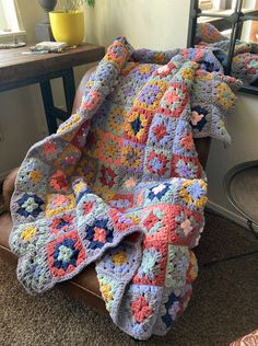 a crocheted blanket sitting on top of a chair