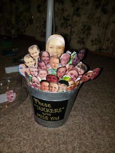 a trash can filled with pictures of people's heads and names on the side