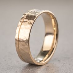 a gold wedding ring on a gray surface