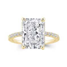 a cushion cut diamond ring with pave diamonds on the band and shoulders, set in 18k yellow gold