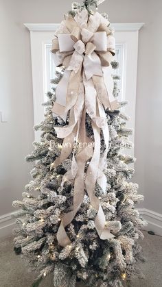 a white christmas tree decorated with bows and lights