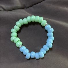 This Bracelet Is Blue And Green Made Out Of Pony Beads With Stretch, Elastic And Pearl Separators Light Blue Beaded Bracelets With Round Beads, Casual Blue Beaded Bracelet With Large Beads, Casual Blue Bracelets With Large Beads, Casual Light Blue Beaded Bracelets, Casual Blue Stretch Bracelet With Large Beads, Casual Large Blue Beads, Blue Stretch Bracelet With Large Beads, Casual Blue Beaded Bracelets With 8mm Beads, Casual Blue Bracelet With Spacer Beads