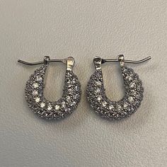 Upgrade from your everyday hoops to our pavé encrusted silver huggie earrings for the perfect amount of glam and sparkle.  Materials: Brass / Pavé Cubic Zirconia Hypoallergenic / Tarnish-Free Small Hoop Cubic Zirconia Crystal Earrings, Small Hoop Silver Cubic Zirconia Earrings, Silver Cubic Zirconia Small Hoop Earrings, Elegant Silver Huggie Earrings For Party, Small Hoop Earrings With Rhinestones In Cubic Zirconia, Silver Hoop Crystal Earrings For Anniversary, Silver Small Hoop Earrings With Sparkling Stones, Small Hoop Silver Diamond Earrings For Pierced Ears, Silver Small Hoop Diamond Earrings For Anniversary