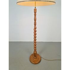 a wooden lamp with a white shade on it's base and a cord attached to the light