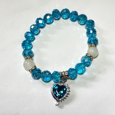 This bracelet is perfect for stacking or wearing on its own.  With sparkly heart charm strung on a stretchy cord with blue beads. Turquoise Heart-shaped Beaded Bracelet, Blue Beaded Bracelets With Heart Beads, Blue Heart-shaped Beaded Bracelets, Blue Beaded Heart Bracelet, Blue Heart-shaped Bracelets For Gifts, Blue Heart-shaped Beaded Bracelet, Blue Heart-shaped Gift Bracelets, Blue Bracelet With Heart And Round Beads, Blue Heart Charm Bracelets As Gifts