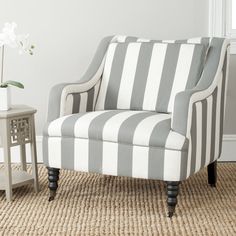 a gray and white striped chair sitting on top of a rug