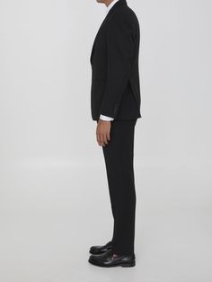 Two-piece suit in black virgin wool. Single-breasted jacket with classiclapels, brooch on lapel, front button closure, two front welt pockets, a welt pocket on chest and buttoned cuffs. Straight-leg trousers with zip, button and hook-and-eye closure, two side welt pockets and two rear buttoned welt pockets. Regular fit. Size nationality: ITComposition: 97% Virgin Wool, 3% Elastane Black Three-piece Tuxedo For Formal Occasions, Luxury Black Three-piece Suit With Single Button, Tailored Black Wool Three-piece Suit, Bespoke Tailored Black Three-piece Suit, Luxury Black Suits With Lapel Collar, Luxury Black Suit With Lapel Collar, Formal Black Single Breasted Tuxedo, Black Single Breasted Tuxedo For Formal Occasions, Timeless Black Blazer For Black-tie Events