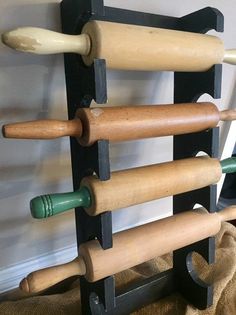 a rack with several rolling doughs on it and two wooden rollers attached to the wall