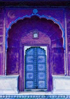 an ornate doorway with blue and purple doors