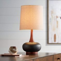 a table lamp sitting on top of a wooden dresser