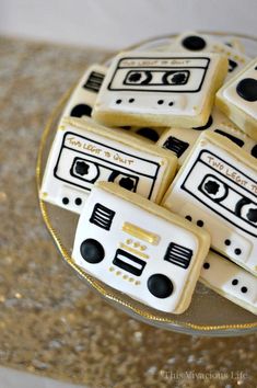 cookies decorated with cassette tape recorders on a glass platter and gold sequins