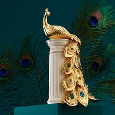 a golden peacock sitting on top of a white pillar next to green wall with feathers