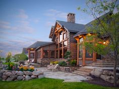 a large log home with stone steps leading up to it