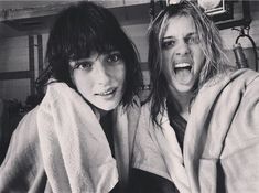 two young women in robes posing for a photo with their mouths open and one holding a towel over her head