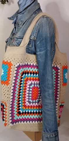 a crocheted bag is displayed on a mannequin's back legs