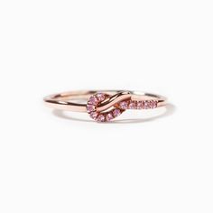 a rose gold ring with pink sapphires on the side and two diamonds in the middle