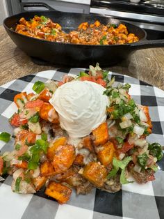 a plate with some food on it and a skillet in the back ground next to it