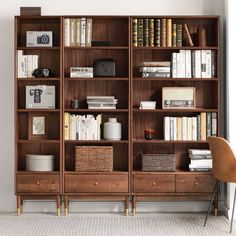 a bookshelf filled with lots of books next to a chair